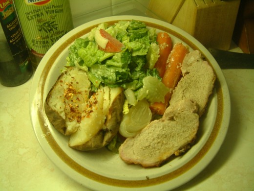 Pork loin roast with carrots, onions, potato and Caesar salad.