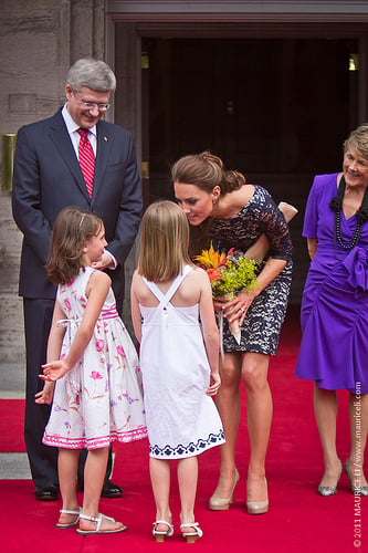 The Duchess receives a welcome bouquet from seven year olds Aurelie Thibault (left), of Chelsea, Que., and Sophie Graydon, of Petawawa, Ont., at Rideau Hall in Ottawa; both girls have parents in the Canadian Forces