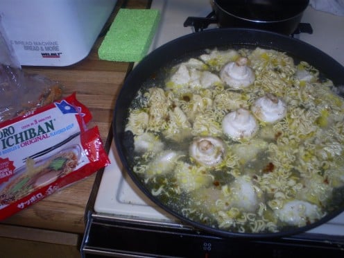 Add some water, Ichiban noodles, and a few mushrooms to the pan.