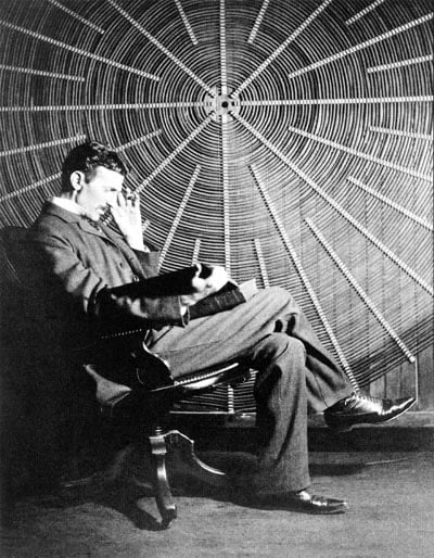 Young Tesla is seated in front of his spiral transformer. He is single handed in his responsibility for the major electrical technological advances of the 20th century.