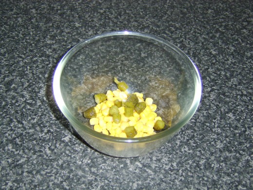 Sweetcorn and chopped pickles are added to a mixing bowl
