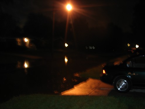 Night time falls on flooded streets and the river is still rising.