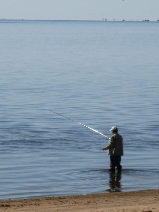 Man fishing in Lake Ilmen outside walls of St George Monastery near Veliky Novgorod, Russia