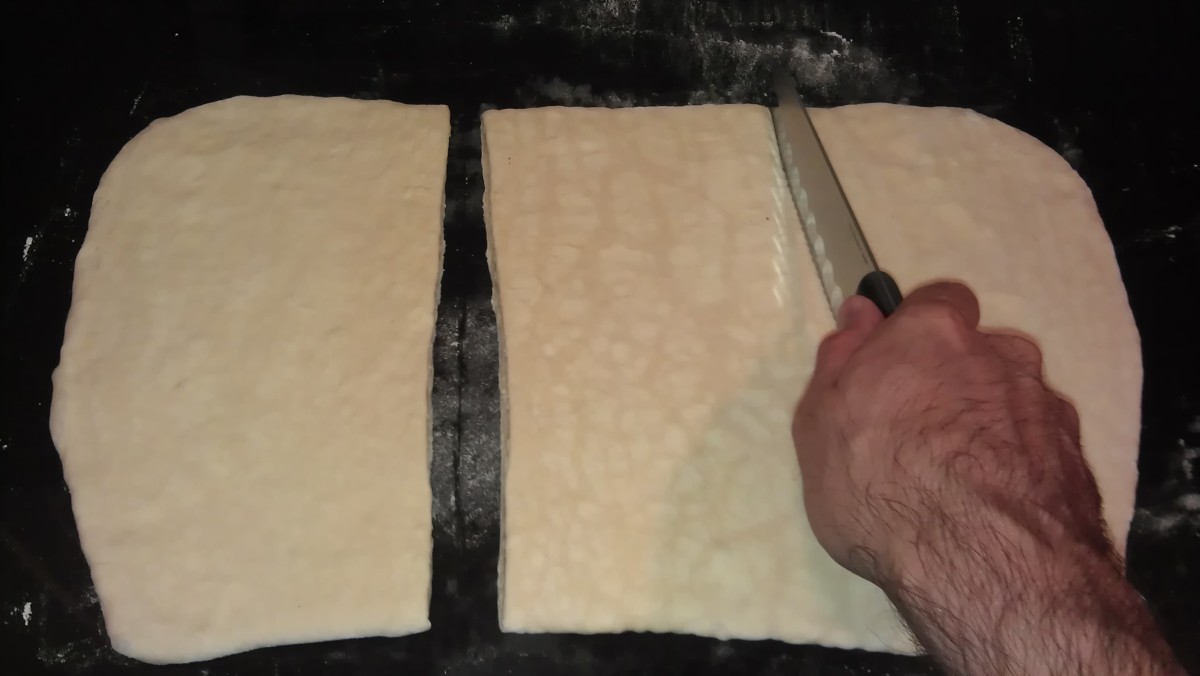 Cut the rolled-out dough into thirds.