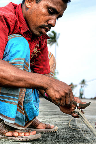 A local fisherman working on his fishing net