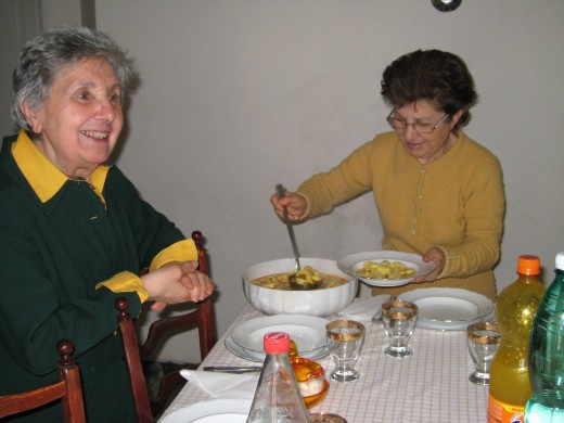 Cousins, Ana and Maria, serving fresh homemade tortellini in brodo (tortellini soup), for our dinner.