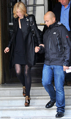 Gwyneth Paltrow clutches her bodyguard to avoid any embarrassing tumbles on the steps