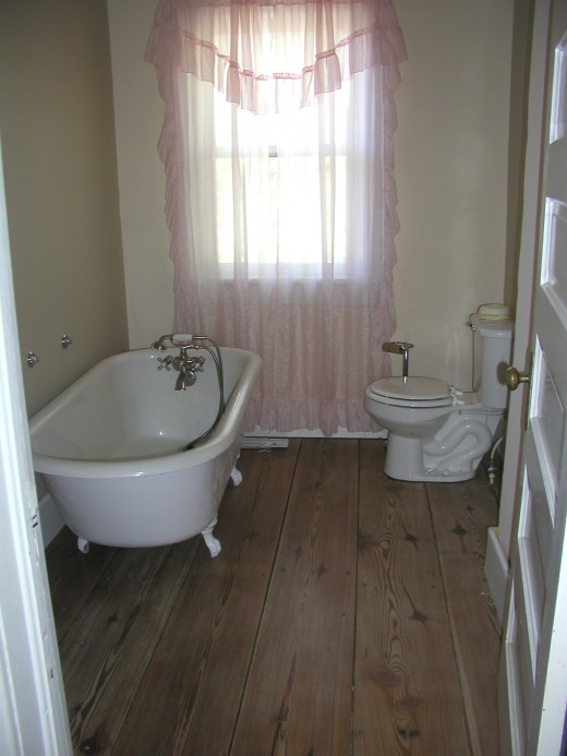 Two bathrooms are upstairs; this one has some of  the original fixtures...clawfoot tub.  The foot wide plank flooring was recalimed, refinished and installed by Al and me. 
