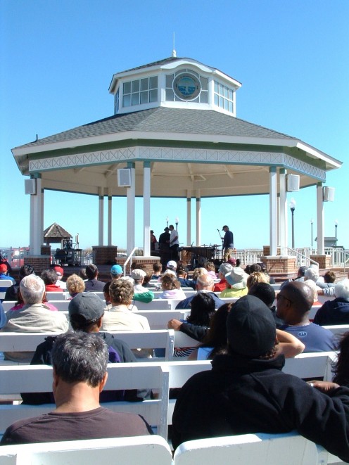 Rehoboth Beach Band Stand. Audience is facing the ocean and boardwalk as they enjoy the free concerts.