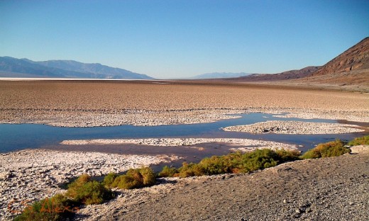 A small salty plot of water at the foot of Death Valley California shimmers an inviting smile but looks are so deceiving