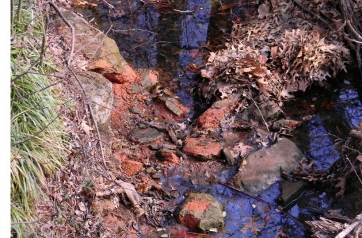  A small drainage creek by the pond.  Its deep azure sky reflection contrasts with Okie red soil and sandstone as I snap the photo from a small bridge.