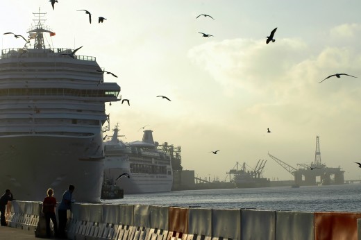 Humans and birds dwarfed against the massive ships and the shipyard in the backgound - Maybe suggestive of the idea that humanity itself is being dwarfed by the concept of The bigger the better