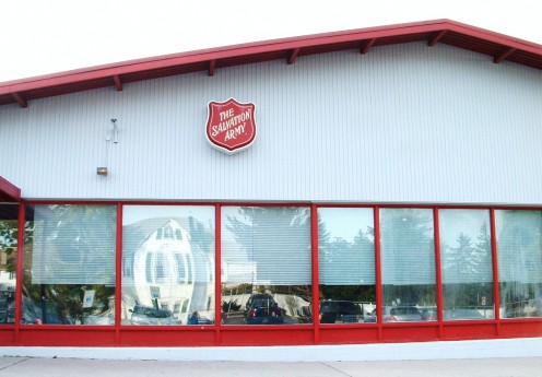 The front of the Salvation Army Family Store Building which faces its own parking lot. The murals are on the long, left side of the building which faces the street. 