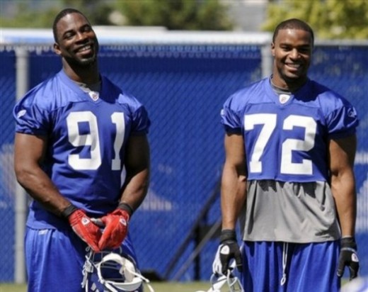New York Giants defensive ends Justin Tuck (91) and Osi Umenyiora smile as they watch teammates during practice