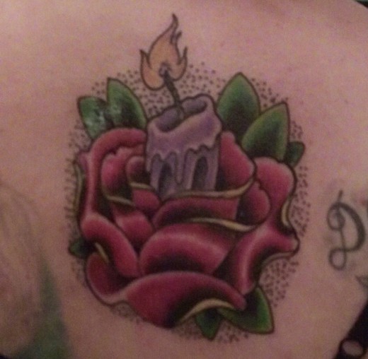Bart Andrews created this traditional candle and rose tattoo for Jami Forsch.