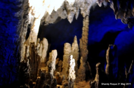 Stalagmite and Stalactite Formations enhanced by blue lights.