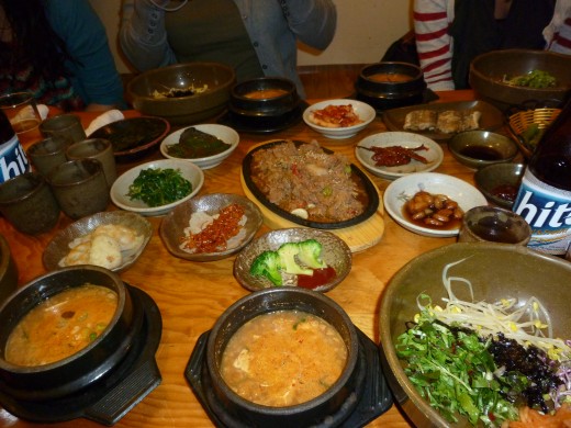 You can see bibimbap off to the right of the picture.  It's a very popular Korean meal.  Usually consists of rice, vegetables, and a little red pepper sauce.  The soup is kimchichigae.  It has vegetables and tofu in it.  It can be pretty spicy. 