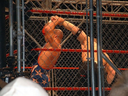 Kurt Angle and John Cena face off in a steel cage match at a WWE house show in the MEN Arena in Manchester, United Kingdom on 17 November, 2005.