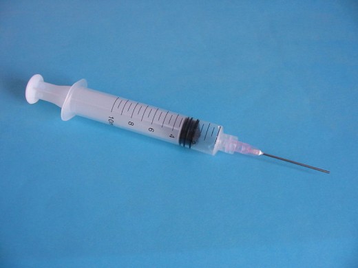 Syringe fitted with needle. Scale in ml.