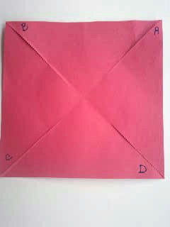 Red construction paper square is slit on four folds.