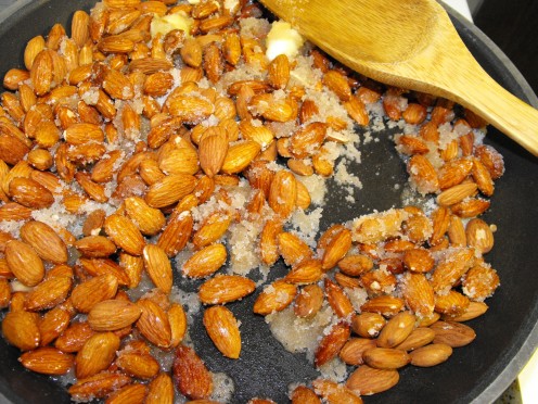 As the butter melts, the sugar starts melting too and clumping/adhering to the almonds.  Keep stirring.
