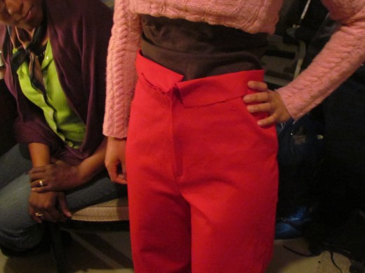 Karen explains to Jaleesa, how they must now get the front of the pants completed after the zipper was installed.