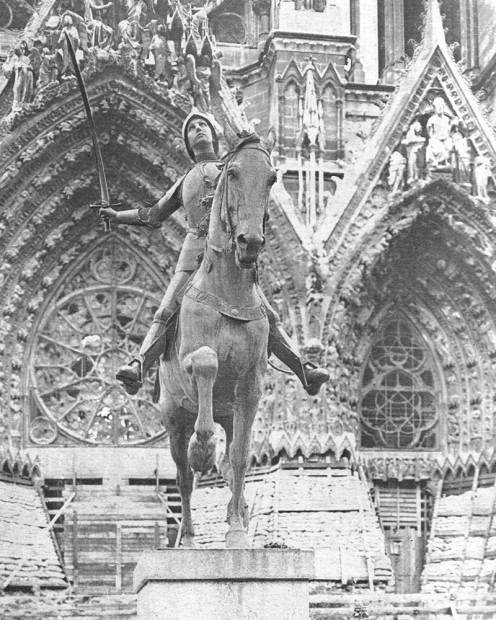 "THE STATUE OF JOAN OF ARC BEFORE THE RHEIMS CATHEDRAL. It was to the great cathedral of Notre Dame at Rheims that Joan of Arc brought Charles VII to be crowned. Her statue, at the close of 1917, remained uninjured despite the ruin of the cathedral"