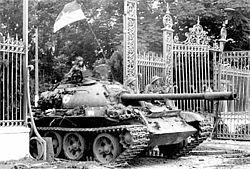 NORTH VIETNAMESE SOLDIER IN A RUSIAN T-54 TANK ROLLING INTO INDEPENDENCE PALACE, SAIGON