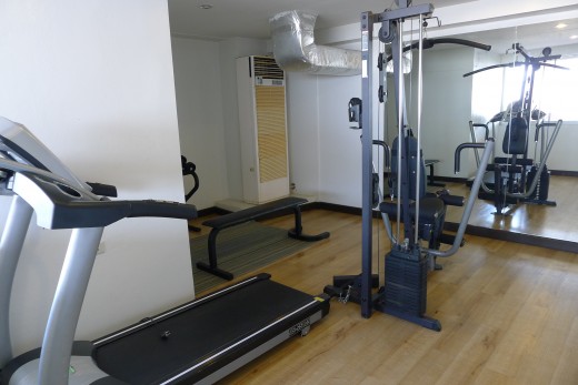 A tiny fitness center with a massive air conditioning unit.