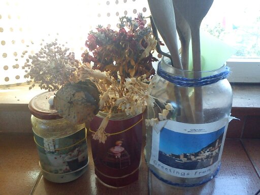 Things tend to look nicer in decorative glass jars.  A little yarn trim is wound around the top of the largest bottle.  I used postcards and rubber bands for a quick and easy look.  The one on the right is soaked, peeled and pasted.