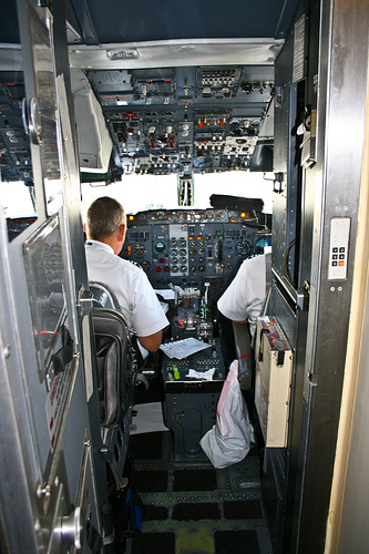Pilots perform their airline jobs in the cockpit.