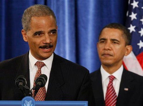 Attorney General Eric Holder at podium with Pres. Obama