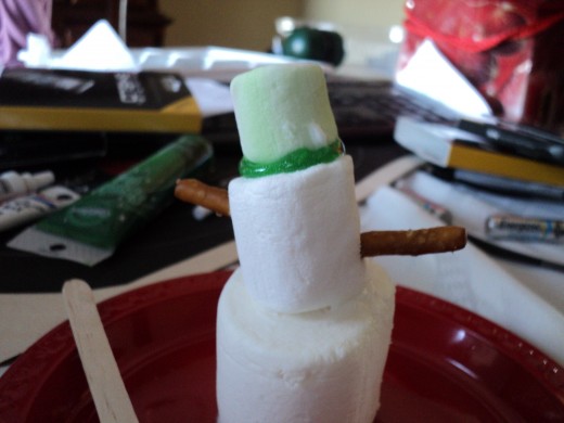 You can make a scarf out of red string licorice or draw one on you snowman with any color of gel frosting.