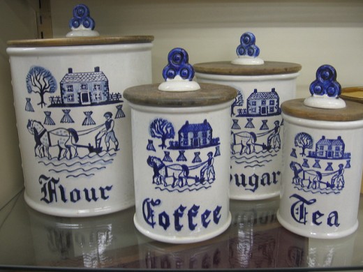 These Dutch inspired canisters are a mixture of ceramic and wood. Notice the intricate details that have been painted on the canister fronts.