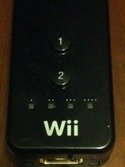 The four lights that correspond with your controller number are above the Wii logo on the front of the Wii Remote.