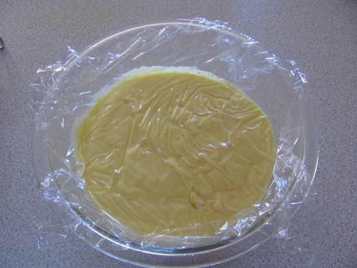 plastic wrap pressed to top of pudding mixture