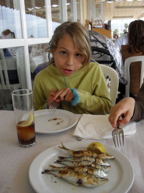 Girl trying grilled sardines for the first time.  Guess what?  She loved them!