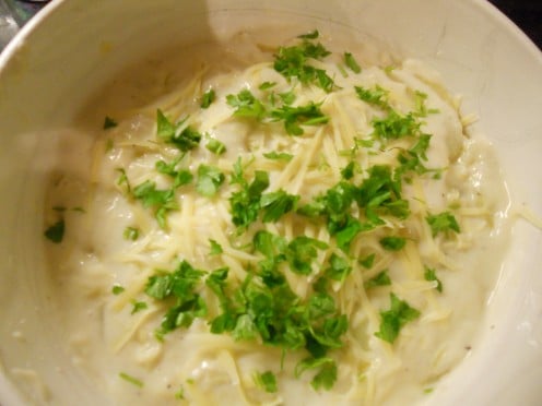 Cheese, potato and onion bake: topped with parsley and ready to cook in the oven ...