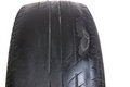 This tire is an example of uneven tread wear and exposed wires.