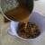 An adult should pour the hot honey mixture into the bowl of oats, prunes, and apricots.