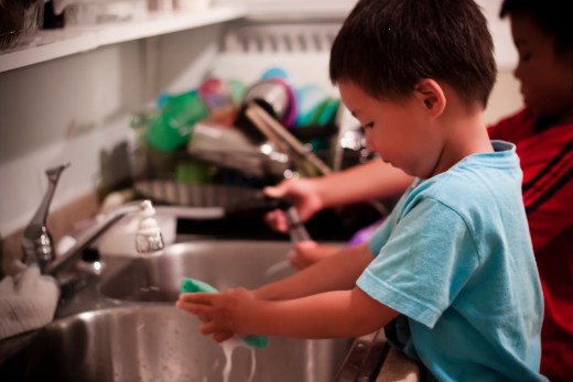 young child washes the dishes