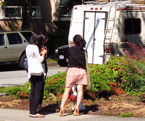 THESE GIRLS ARE AMAZED AT SOMEONE'S CARELESS PARKING BEHAVIOR--PARKING TOO CLOSE TO A FIRE HYDRANT.