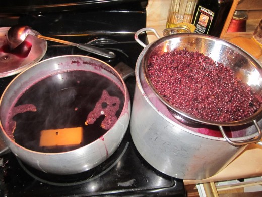 Boiling the dye (elderberries) and straining it.