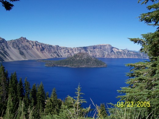 View of Wizard Island through trees at Crater Lake.