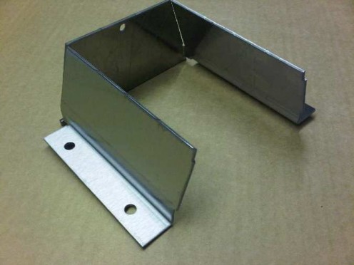 Stainless steel sheet metal angle bracket part of a much larger stainless housing assembly.