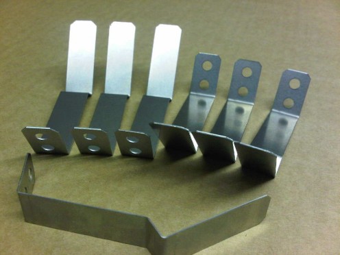 Spring stainless steel angles brackets.  Again, these are used in light fittings but this time to hold a spinning reflector in place within a larger housing.