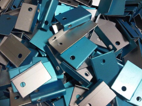 Aluminium pre-anodised reflector material angles ready for small light fittings.  The blue colour is a peelable plastic film that will be removed by the customer when fitting the reflector into the light housing.  It helps to keep the reflector clean