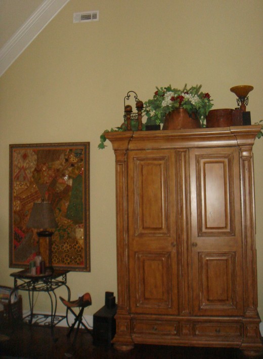 The larger wall hanging on the left is proportionate with the high ceilings and tall armoire.