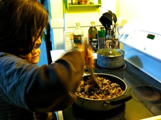 My 9 year old helps by stirring the vegetarian taco filling