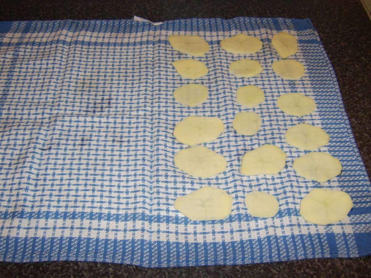 Potato discs are patted dry in a clean tea towel